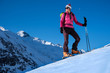 Young woman with skis in winter mountains
