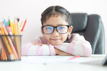 Little Asian girl doing homework and smile with happiness for education concept select focus shallow depth of field