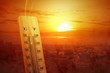 © Leo Lintang - Thermometer with high temperature on the city with glowing sun background