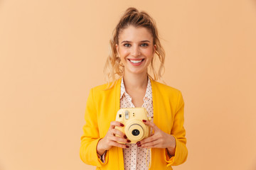 Wall Mural - Photo of happy caucasian woman smiling and holding retro camera