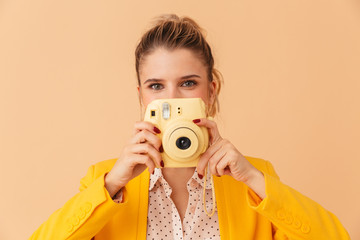 Poster - Photo of joyful caucasian woman smiling and using retro camera