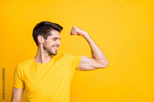Fotografía Photo of young handsome guy holding fist raised demonstrating perfect big biceps
