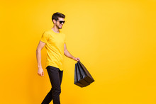 Photo Of Handsome Guy Holding Boutique Bags Making Abroad Shopping Going Down Fashionable Mall Floor Wear Casual T-shirt Pants Isolated Yellow Color Background