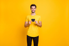 Portrait Of His He Nice Attractive Cheerful Cheery Affectionate Guy Holding In Hands Small Little Black Heart Like Human Healthcare Isolated Over Bright Vivid Shine Vibrant Yellow Color Background