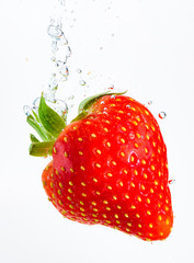 Wall Mural - Strawberry falls deeply under water with a big splash. Fruit sinking in clear water on white background