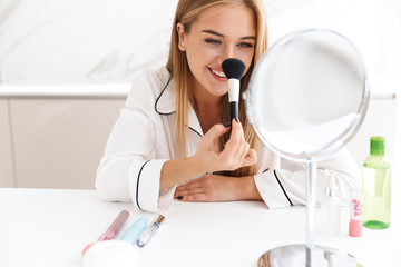 Sticker - Photo of happy cute woman using powder brush and smiling