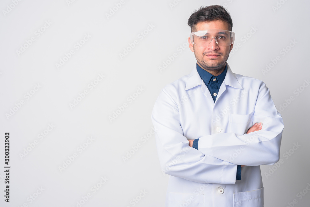 Portrait of young Persian man doctor as scientist with arms crossed - obrazy, fototapety, plakaty 