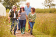 © Monkey Business - Group Of Mature Friends Walking Along Path Through Yurt Campsite