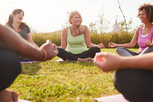 Group Of Mature Men And Women In Class At Outdoor Yoga Retreat Sitting Circle Meditating