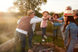 © Monkey Business - Group Of Mature Friends Making Toast As They Sit Around Fire And Sing Songs At Outdoor Campsite