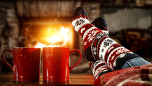 Woman Legs With Christmas Socks And Fireplace In Home Interior. 
