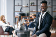© alfa27 - Personable businessman wearing formal black tuxedo stand posing in office environment and look at camera and smile . Business people concept