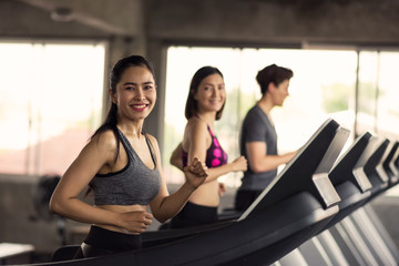 Happy friends run exercise on treadmills