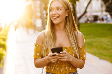 Poster - Beautiful young blonde girl using mobile phone