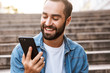 © Drobot Dean - Smiling young man using mobile phone