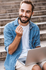 Poster - Handsome smiling young man using laptop computer