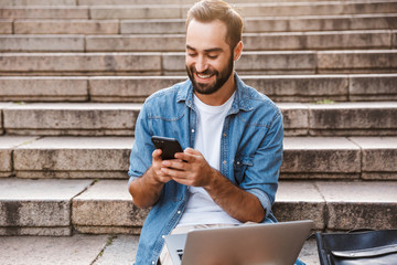 Poster - Happy smiling young man using laptop computer