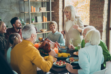 Big family happy thanksgiving gathering sit table pensioner woman hold champagne glass toast to small little kids people enjoy october event feasting with roasted chicken dishes in house