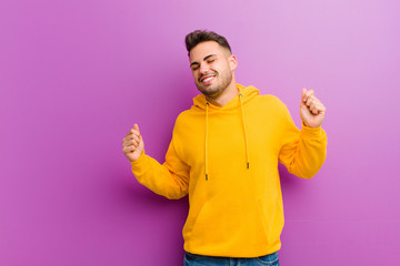 Wall Mural - young hispanic man with casual look against purple background