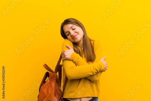 Fotomural young pretty woman feeling in love, smiling, cuddling and hugging self, staying
