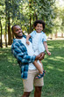 © LIGHTFIELD STUDIOS - happy african american man holding in arms cute curly kid