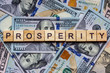 The word prosperity on dollar usa background. Welfare, sufficiency and wealth concept