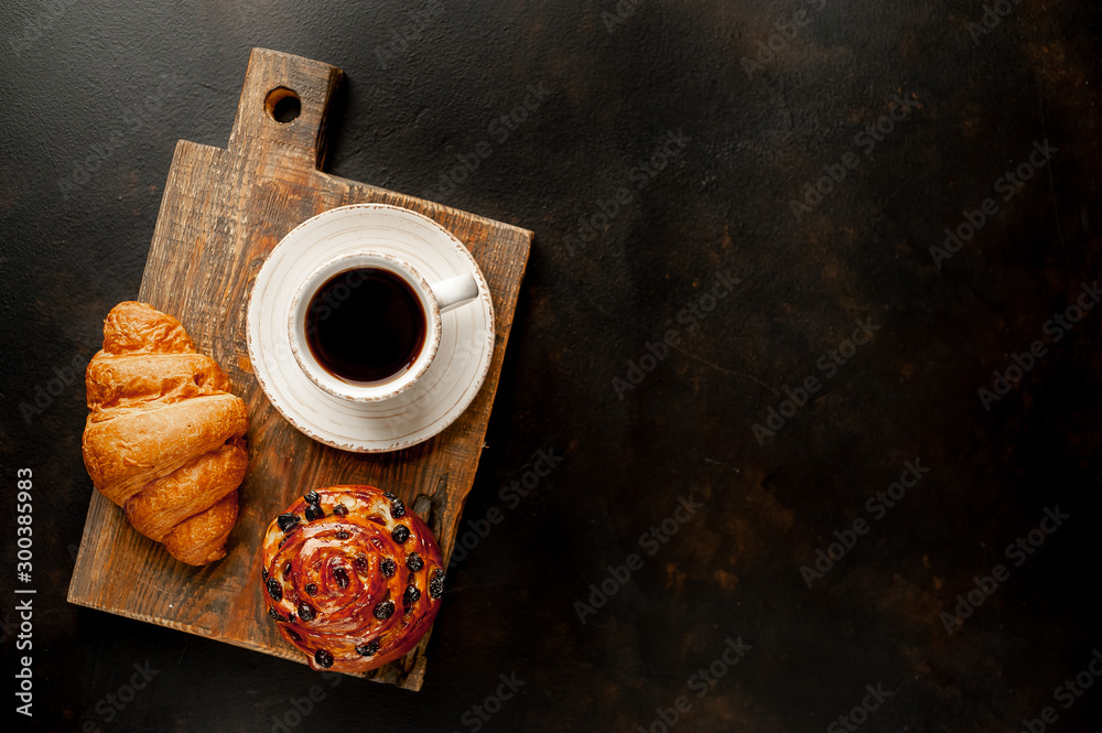 Coffee and croissant, bun on a stone table. morning breakfast, with copy space for text - obrazy, fototapety, plakaty 