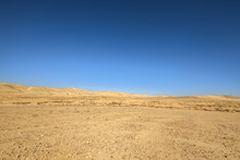 Far Hills In Desert Under Blue Sky