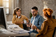 © Drazen - Young businessman using touchpad while having a meeting with female colleagues.