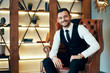 © GVS - Smiling handsome man sitting and posing in armchair in modern luxury interior