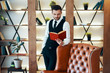 © GVS - Handsome young man in elegant suit reading a book in modern luxury interior