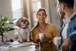 © Drazen - Young business colleagues talking on coffee break while their dog in sitting on the table.