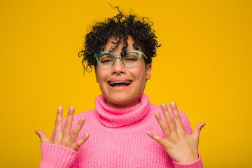 Wall Mural - Young african american woman wearing a pink sweater screaming with rage.