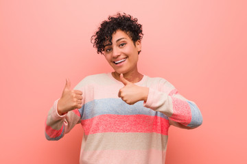 Wall Mural - Young mixed african american teenager woman raising both thumbs up, smiling and confident.