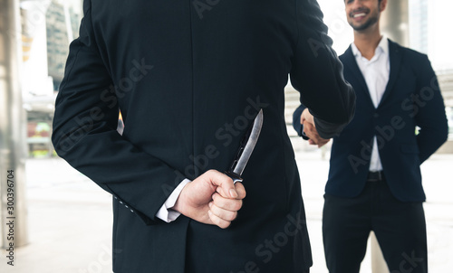 Fotografía two business making handshake a deal but hiding knives
