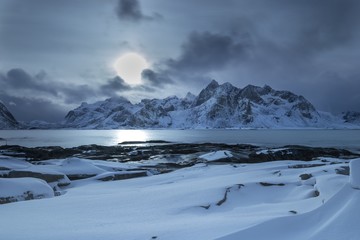 Poster - Frozen sea with the snow covered mountains in the background under the cloudy sky in Norway