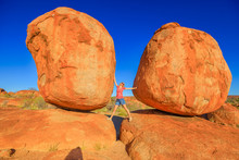 Tourist Woman Enjoying Between Most Iconic Granite Boulders In Karlu Karlu-Devils Marbles Conservation Reserve In Northern Territory, Australian Outback: The Eggs. Lifestyle Female Travel In Australia