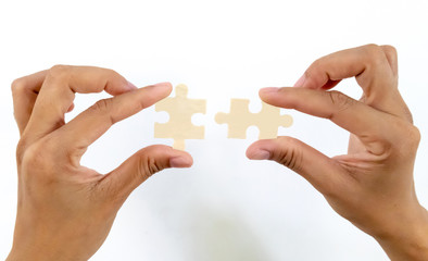 hands female merging 2 jigsaw puzzle pieces against isolated on white background, connection concept