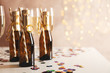 Champagne glasses and mini bottles on decorated background, space for text