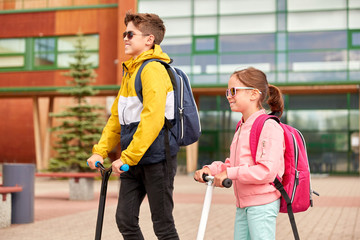 Sticker - education, childhood and people concept - happy school children with backpacks and scooters outdoors