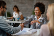 © Drazen - Black happy financial advisor shaking hands with clients in the office.