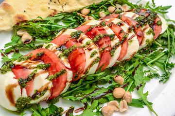 Wall Mural - Italian trditional caprese salad with pesto sauce and basil