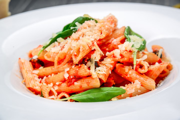 Wall Mural - Penne pasta with shrimp and mussels, tomato sauce, basil and grated parmesan cheese