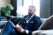 © opolja - Thoughtful handsome businessman thinking while sitting in his modern office about business concept while sitting on sofa