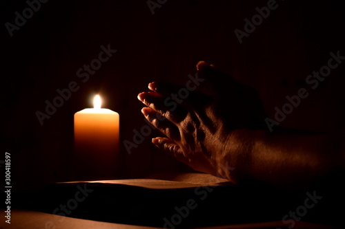 Cuadros en Lienzo Religious prayer with a candle in complete darkness