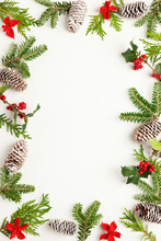Christmas Background With Pine Cones, Branches Of Holly With Red Berries And Fir Tree On White. Winter Festive Nature Concept. Flat Lay, Copy Space.