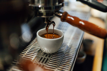 Process of making black coffee from espresso machine, coffee in white cup