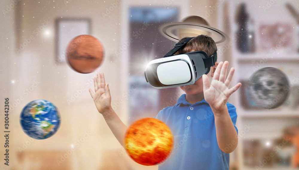 Boy with a virtual reality headset exploring planets in his room. The ...
