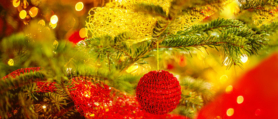 Wall Mural - Christmas tree and Christmas decorations with red baubles and blurry golden bokeh lights. Happy New Year and Xmas Card.