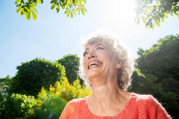 Close up happy middle aged woman laughing outside